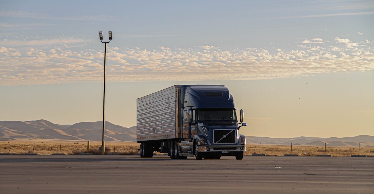 A sleeper cab and reefer trailer parked at dusk